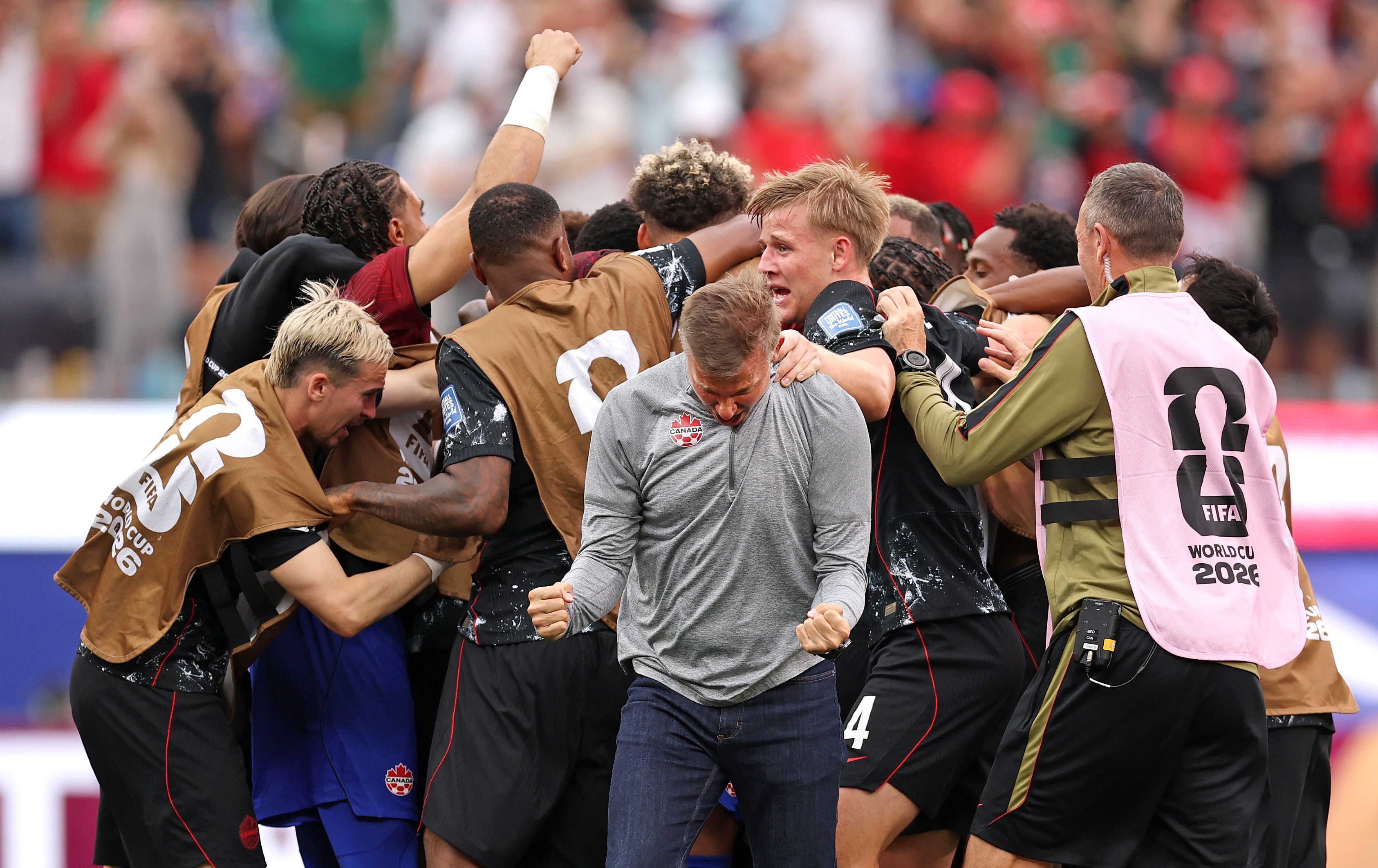 Jesse Marsch celebrates in front of a Canadian huddle