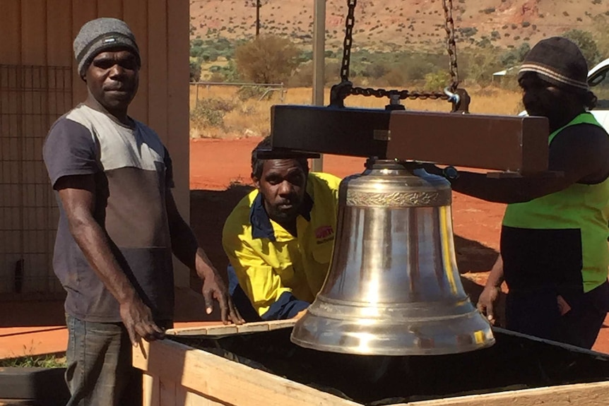 Kintore community members with bell and tower