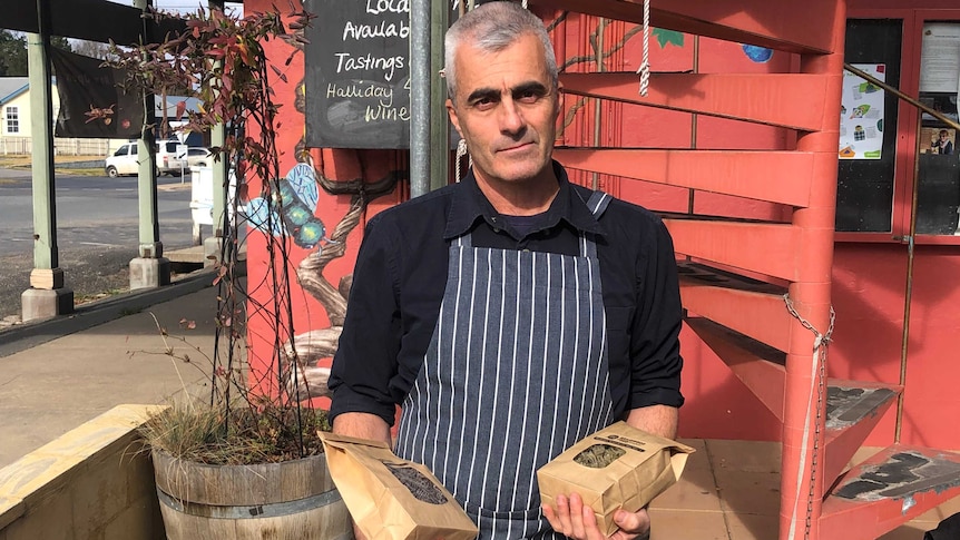 Tim Winbourne holds packets of pasta that he makes outside a delicatessen in Braidwood