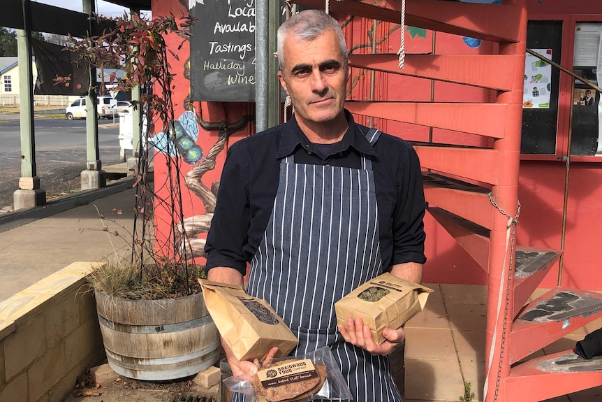 Tim Winbourne holds packets of pasta that he makes outside a delicatessen in Braidwood