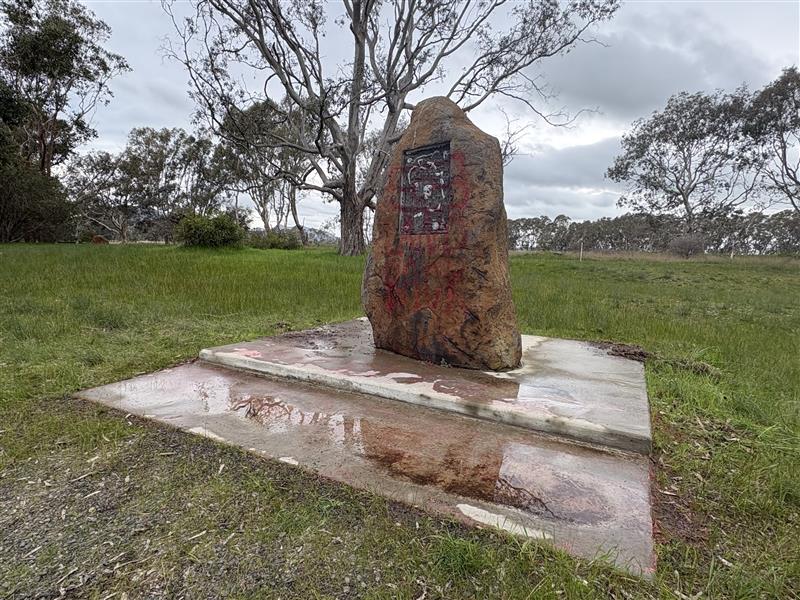 Red spray paint on a war memorial.