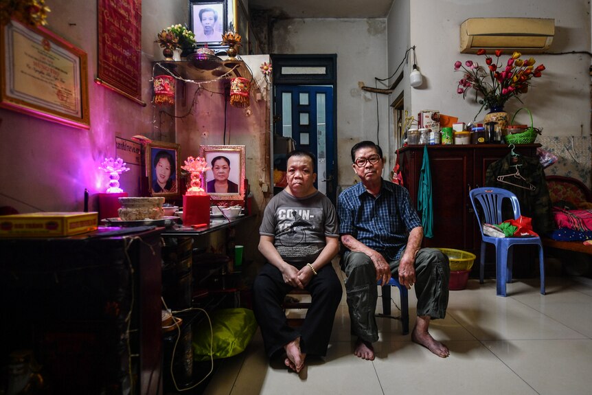 Binh Phan and his son Thien Vu sit in their home in Vietnam