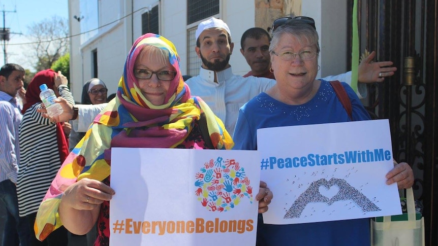Visitors to Marion Mosque hold up signs of peace.