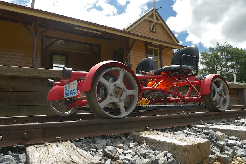 A specially designed rail bike in front of a heritage train station.