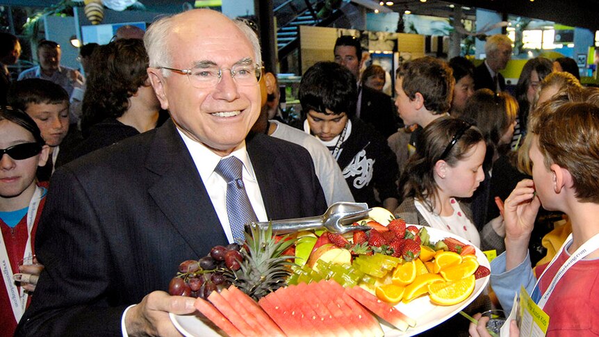 John Howard hands out fresh fruit to schoolchildren during the launch of a healthy eating plan for Australian children