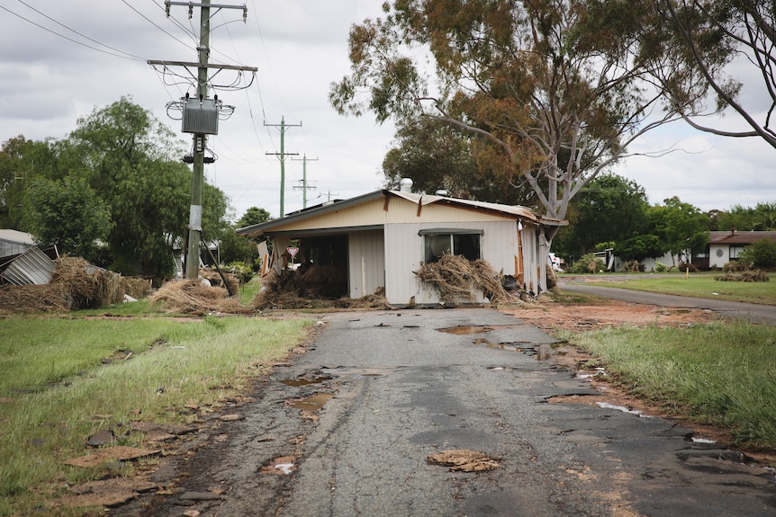 A destroyed home in the middle of the road.