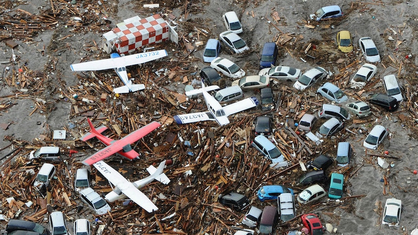 Aeroplanes lie in tsunami debris at Sendai Airport