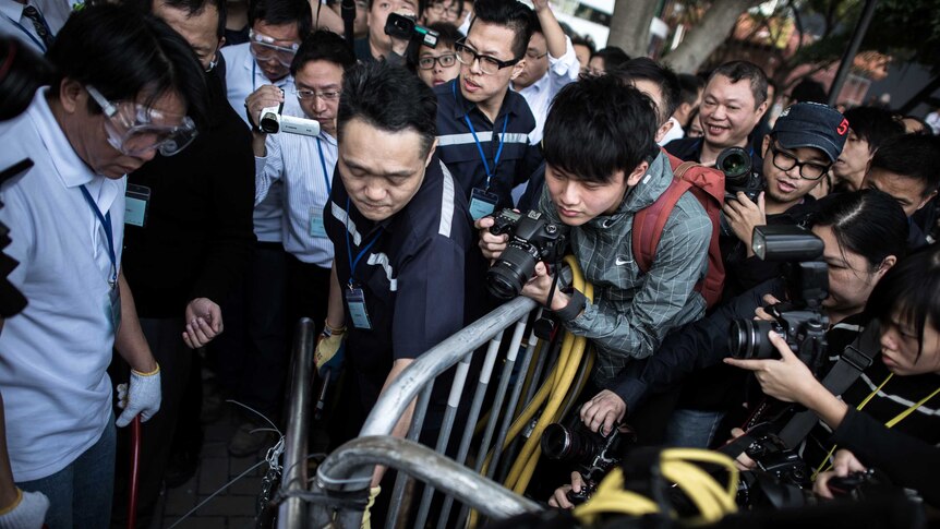 Security staff remove barricades near a protest site in Hong Kong