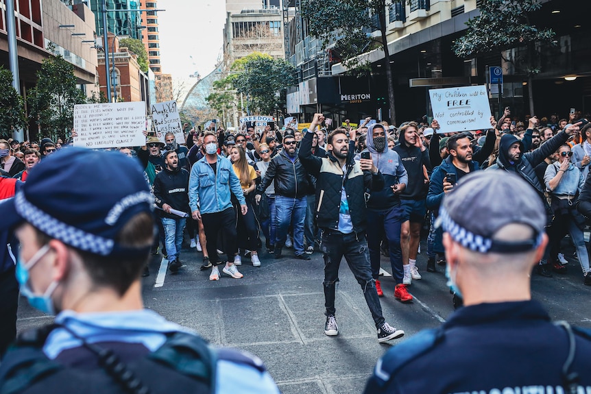 people screaming in front of a police line