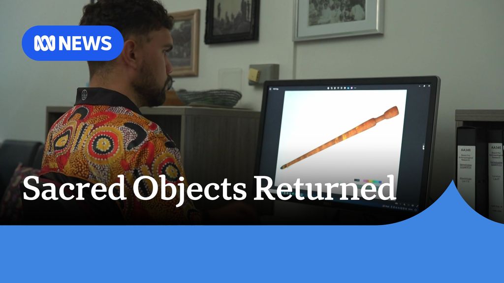 Sacred Objects Returned: A man sits in front of a compute screen in an office.