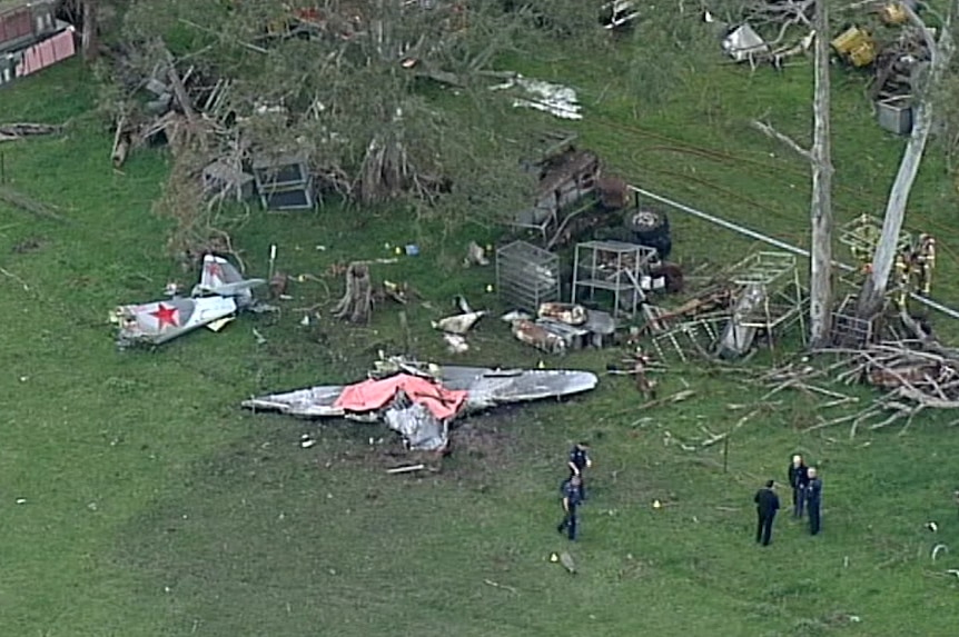 Plane crash wreckage in a paddock.