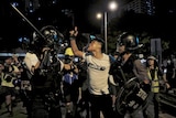 A bleeding man reacts as he is taken away by policemen in Hong Kong.