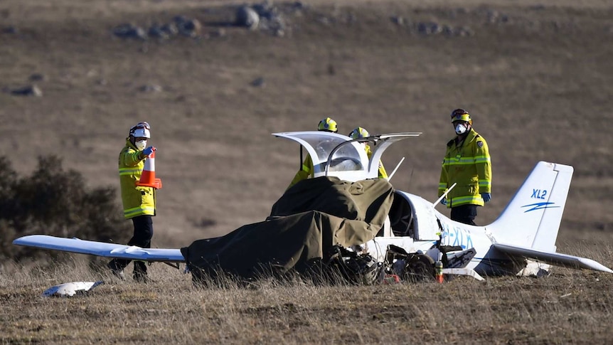 Emergency services workers surround the wreckage of the plane.