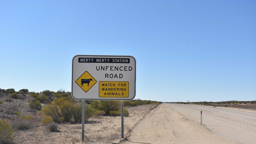 An 'unfenced road' sign next to an outback track with corrugations.