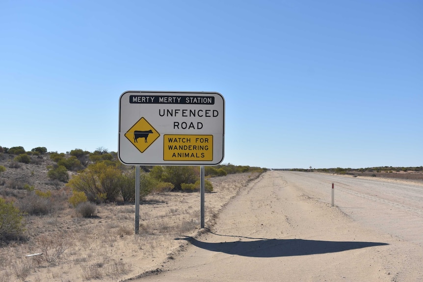 An 'unfenced road' sign next to an outback track with corrugations.