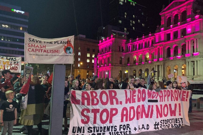 Protesters hold anti-Adani banners in Brisbane square.
