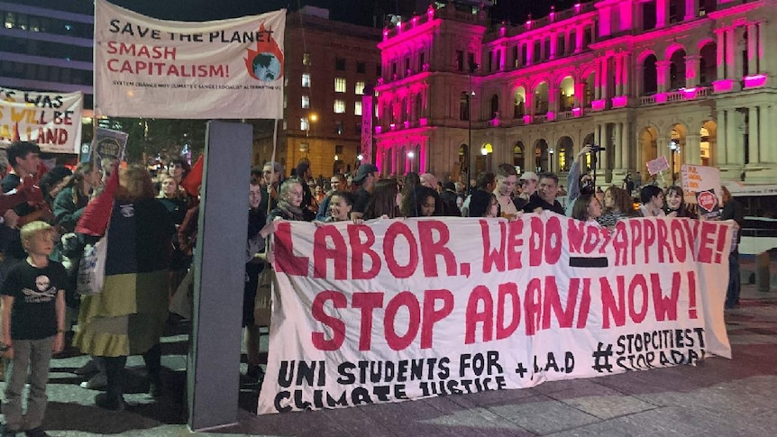 Protesters hold anti-Adani banners in Brisbane square.