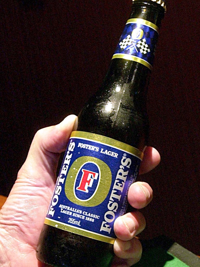 A man holds a Foster's stubby