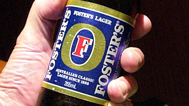 A man holds a Fosters stubby