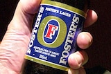 A man holds a Foster's stubby