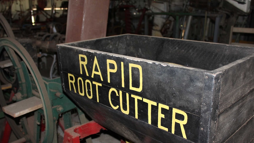 An old-looking piece of farming machinery with the label 'rapid root cutter'