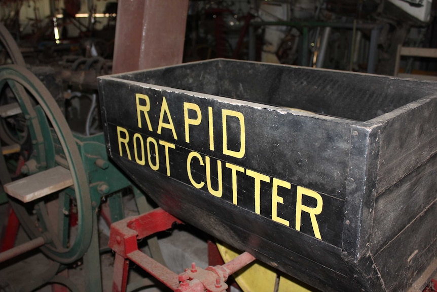 An old-looking piece of farming machinery with the label 'rapid root cutter'