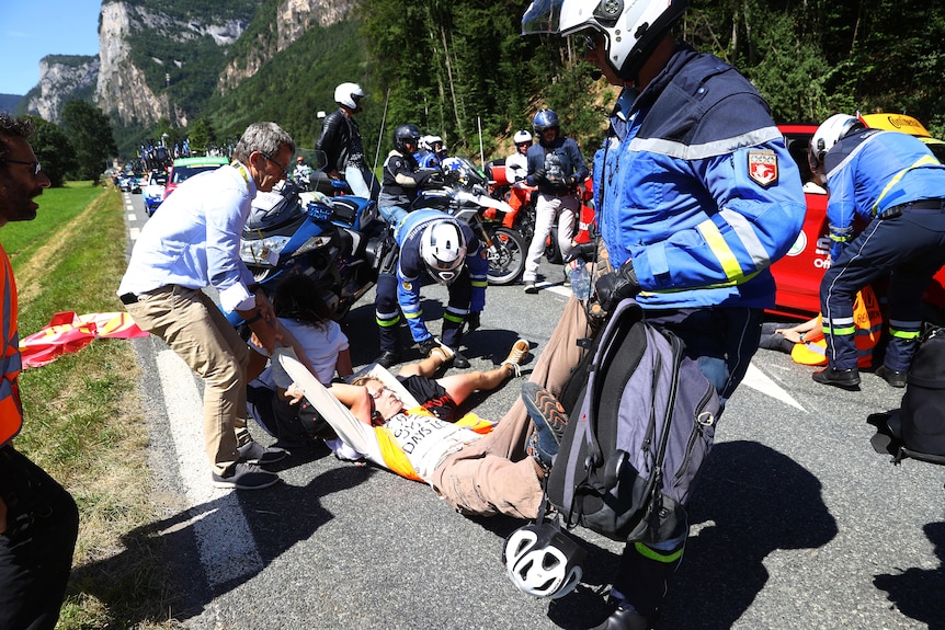 Police attempt to remove protesters at the Tour de France.
