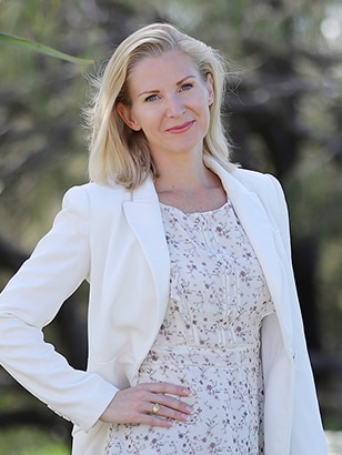 A woman with blond hair posing with her hand on her hip