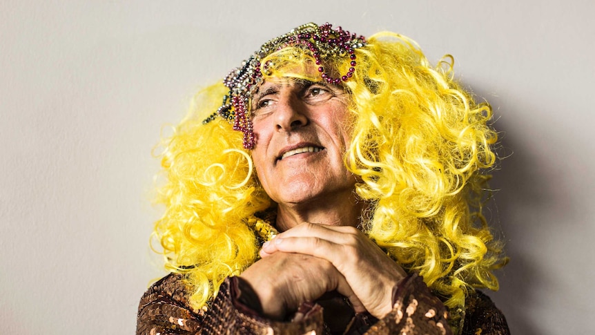 Close up of Kim Gotlieb wearing yellow-blond wig with beads, and a sequinned dress.