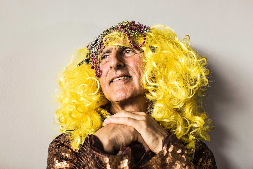 Close up of Kim Gotlieb wearing yellow-blond wig with beads, and a sequinned dress.
