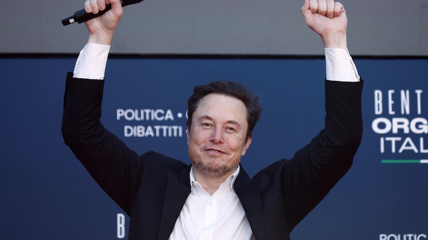 Tesla and SpaceX's CEO Elon Musk gestures at an event.