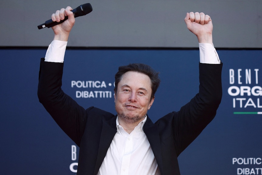 Tesla and SpaceX's CEO Elon Musk gestures at an event.