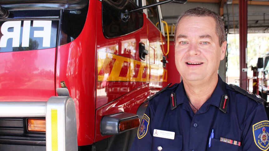 A profile shot of David Letheby standing in front of a fire truck