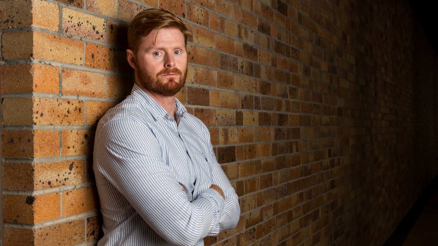 Dr Matt Dun leans against a wall.