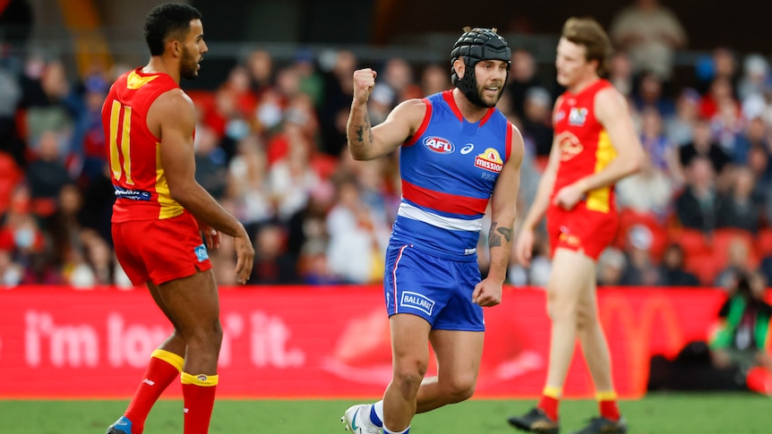 A Western Bulldogs AFL player pumps his right fist as he celebrates a goal against Gold Coast.