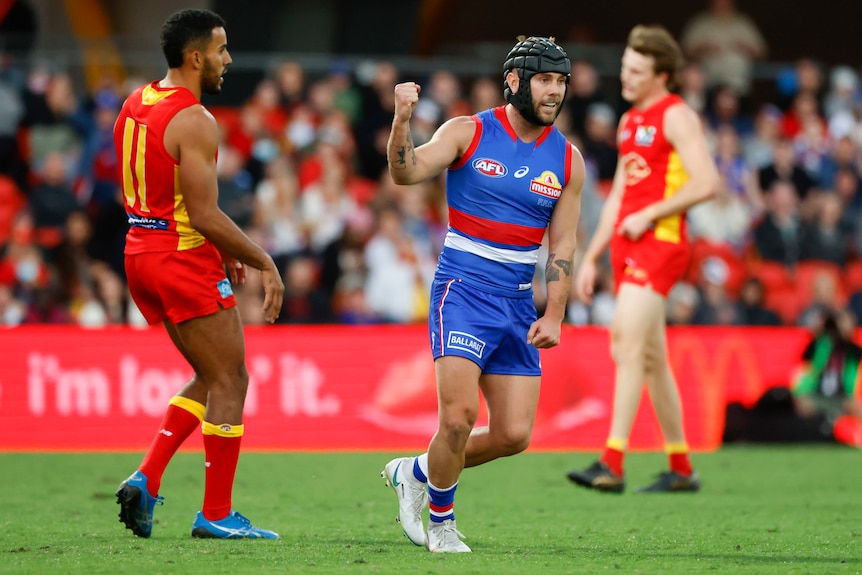 A Western Bulldogs AFL player pumps his right fist as he celebrates a goal against Gold Coast.