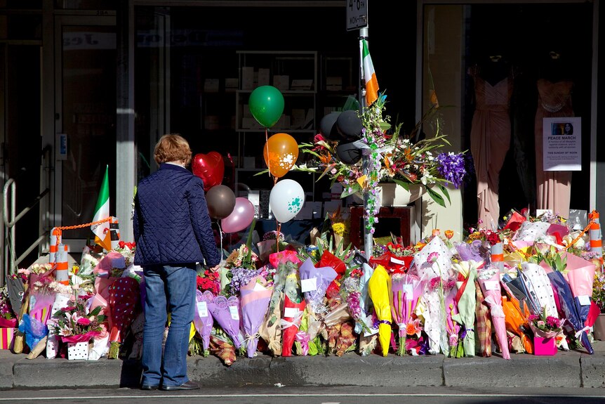 A woman stands in front of the sea of floral tributes left in memory of Jill Meagher on Sydney Road.