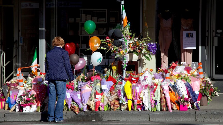 A woman stands in front of the sea of floral tributes left in memory of Jill Meagher on Sydney Road.