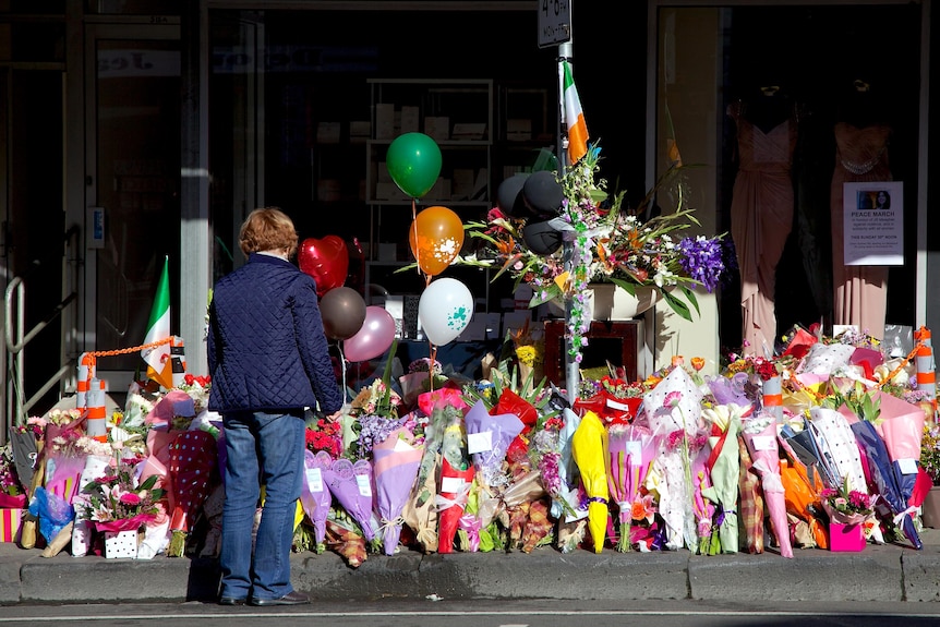 A woman stands in front of the sea of floral tributes left in memory of Jill Meagher on Sydney Road.