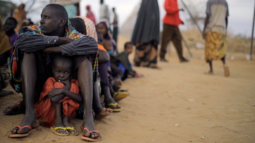 Father shelters daughter at Dadaab refugee camp (AFP: Tony Karumba)