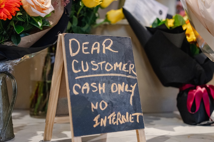 Sign in a florist saying "dear customer, cash only, no internet"