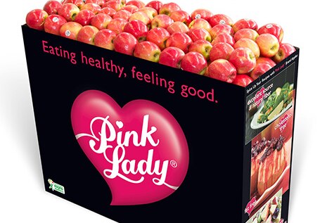 Box of shiny red apples with logo Pink Lady and message Eating healthy, feeling good