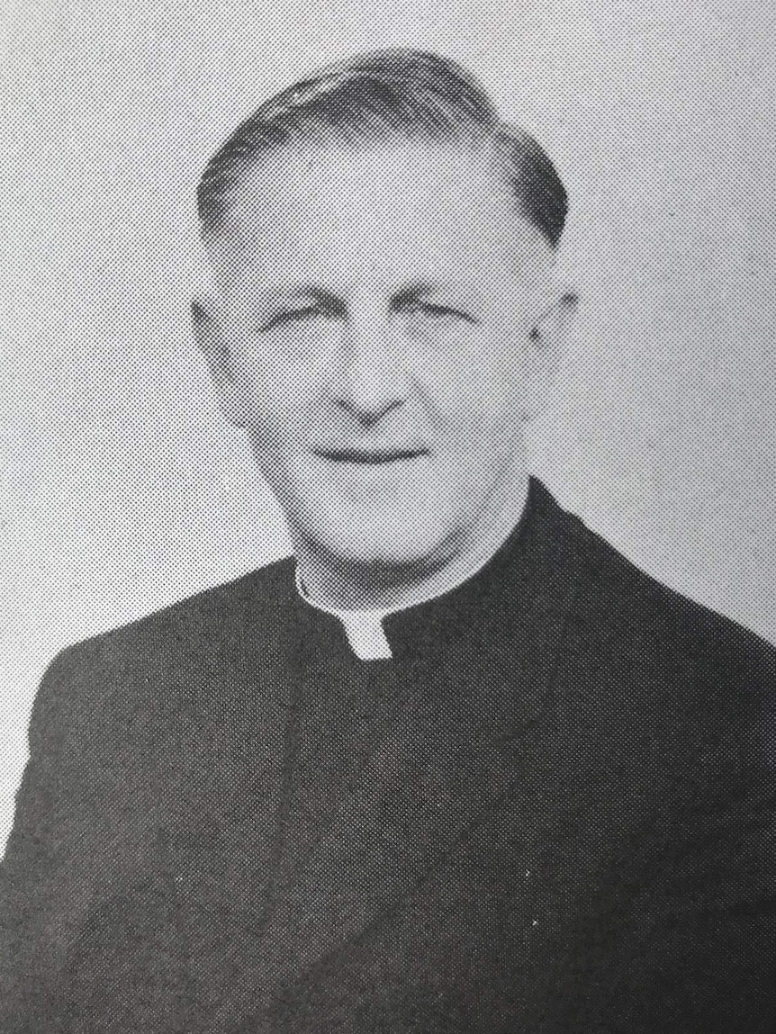 A black and white yearbook-style picture of a priest