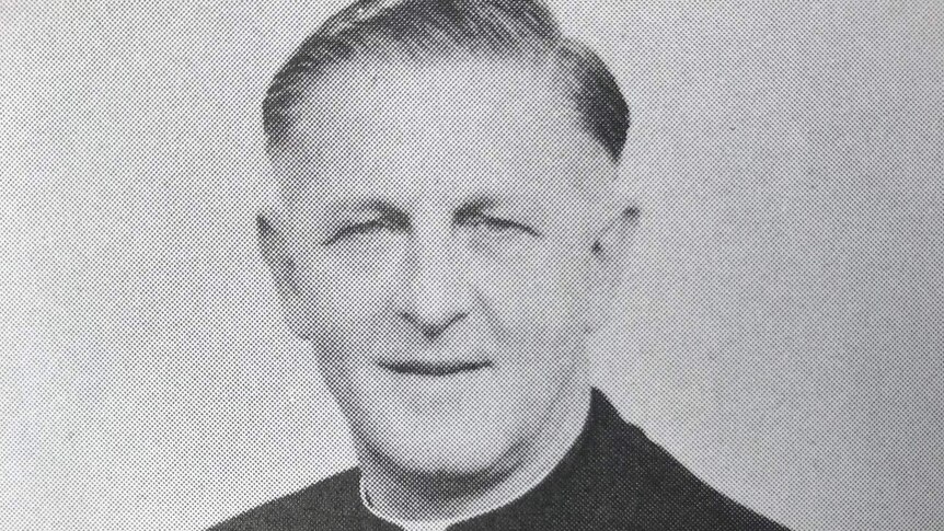 A black and white yearbook-style picture of a priest