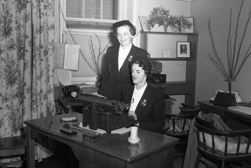 Tow policewomen at a typewriter.