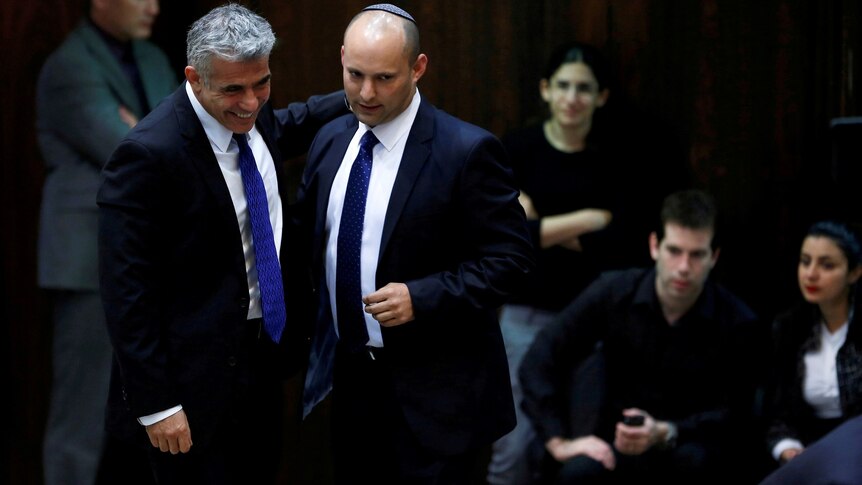 Yair Lapid (left) and Naftali Bennett (second from left) walk together in 2013.