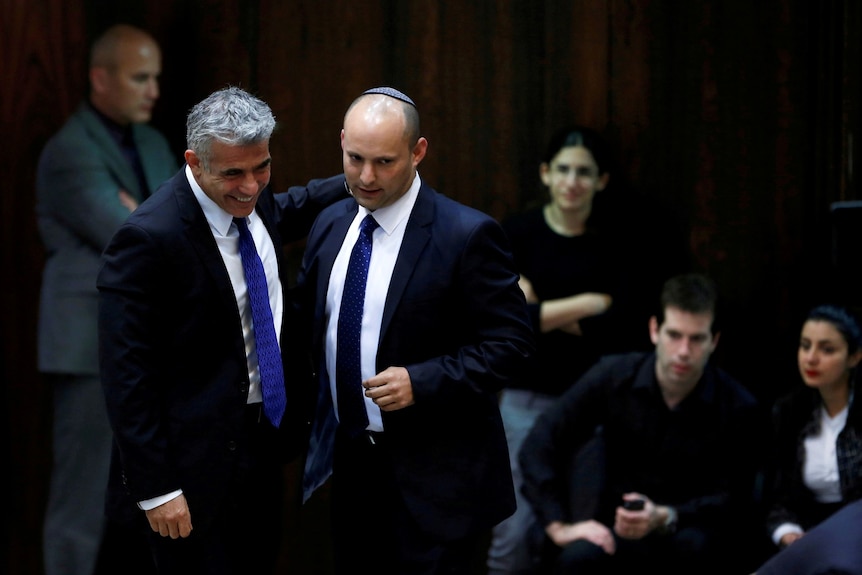 Yair Lapid (left) and Naftali Bennett (second from left) walk together in 2013.