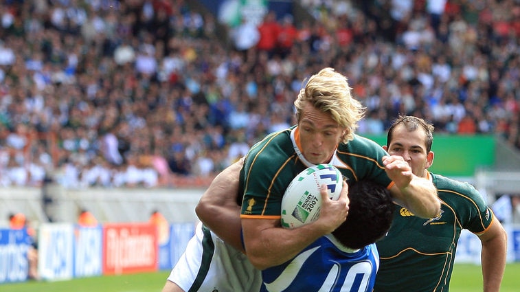 South African full-back Percy Montgomery gets tackled by Eliota Fuimaono-Sapolu