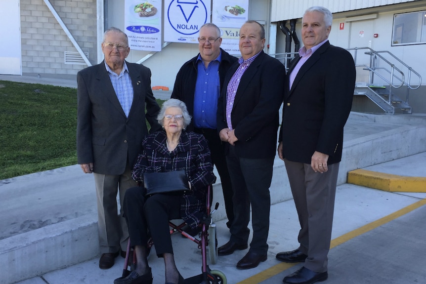 Mr and Mrs Nolan who is sitting in a wheelchair, surrounded by their sons.