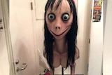 An image of the Momo Challenge, a woman with large eyes, chicken feet and breasts.
